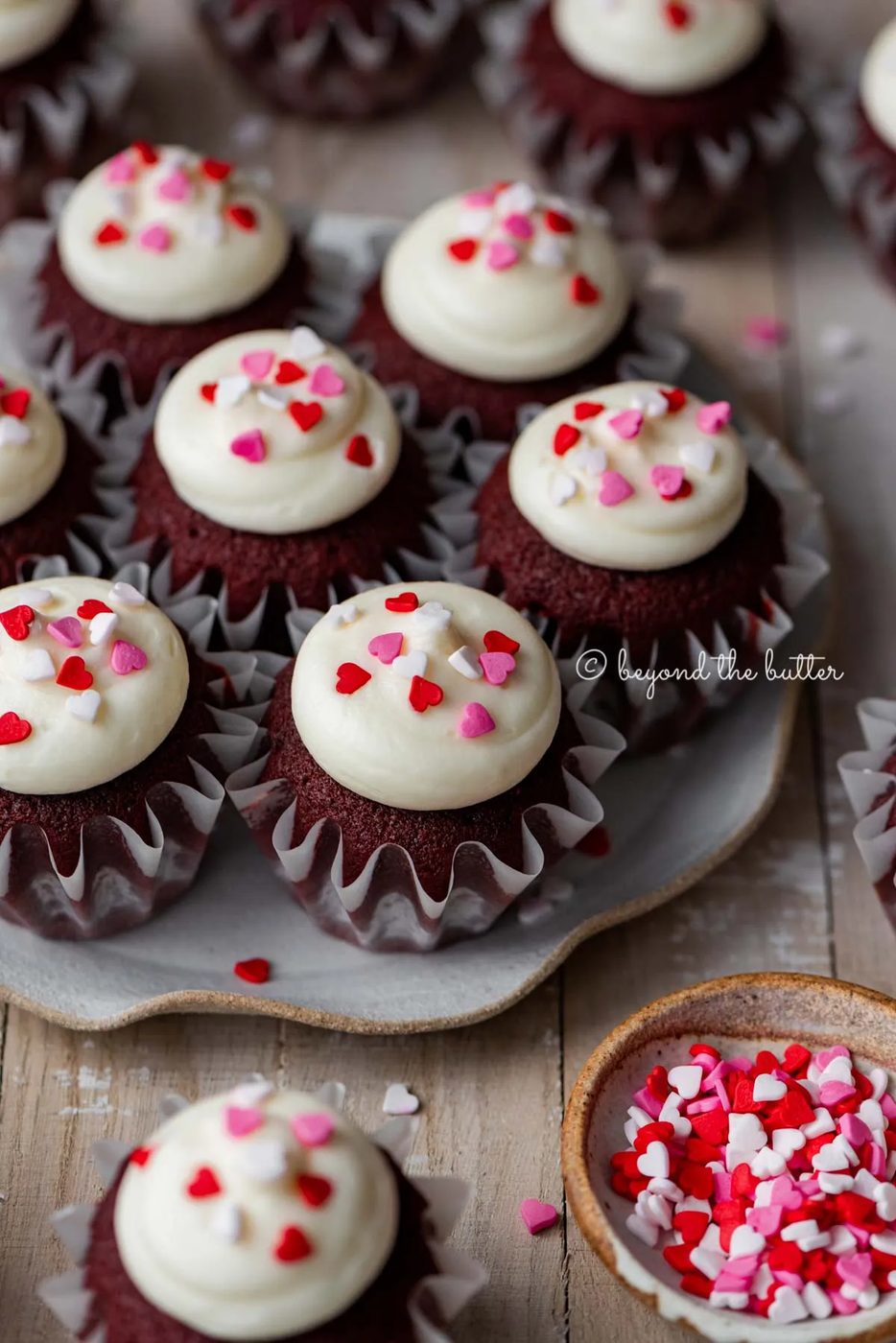 Dessert plate with house-made red velvet cupcakes with cream cheese frosting topped with heart sprinkles on a light wood background | All images © Sovuh