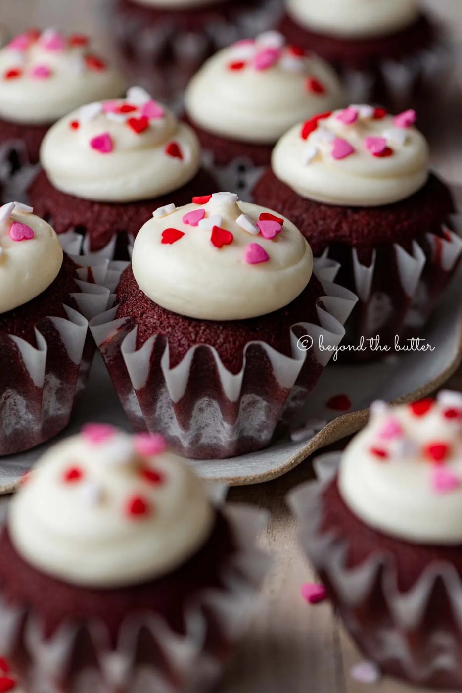 Dessert plate with house-made red velvet cupcakes with cream cheese frosting topped with heart sprinkles on a light wood background | All images © Sovuh
