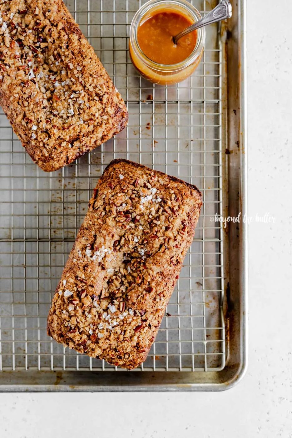 Overhead image of 2 loaves of banana nut bread on a wire cooling rack | All Images © Sovuh