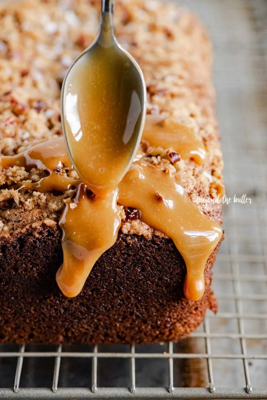 Angled image of salted caramel banana nut bread loaves on a wire cooling rack with caramel drizzled over the top | All Images © Sovuh