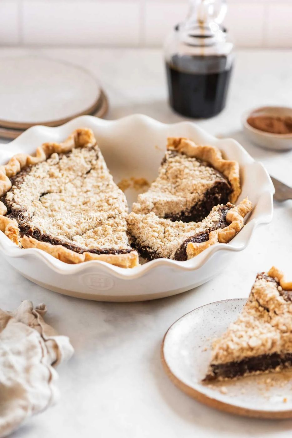 Pie plate with slices of pennsylvania dutch shoo fly pir removed and set on dessert plates with glass of molasses in the background | All Images © Sovuh