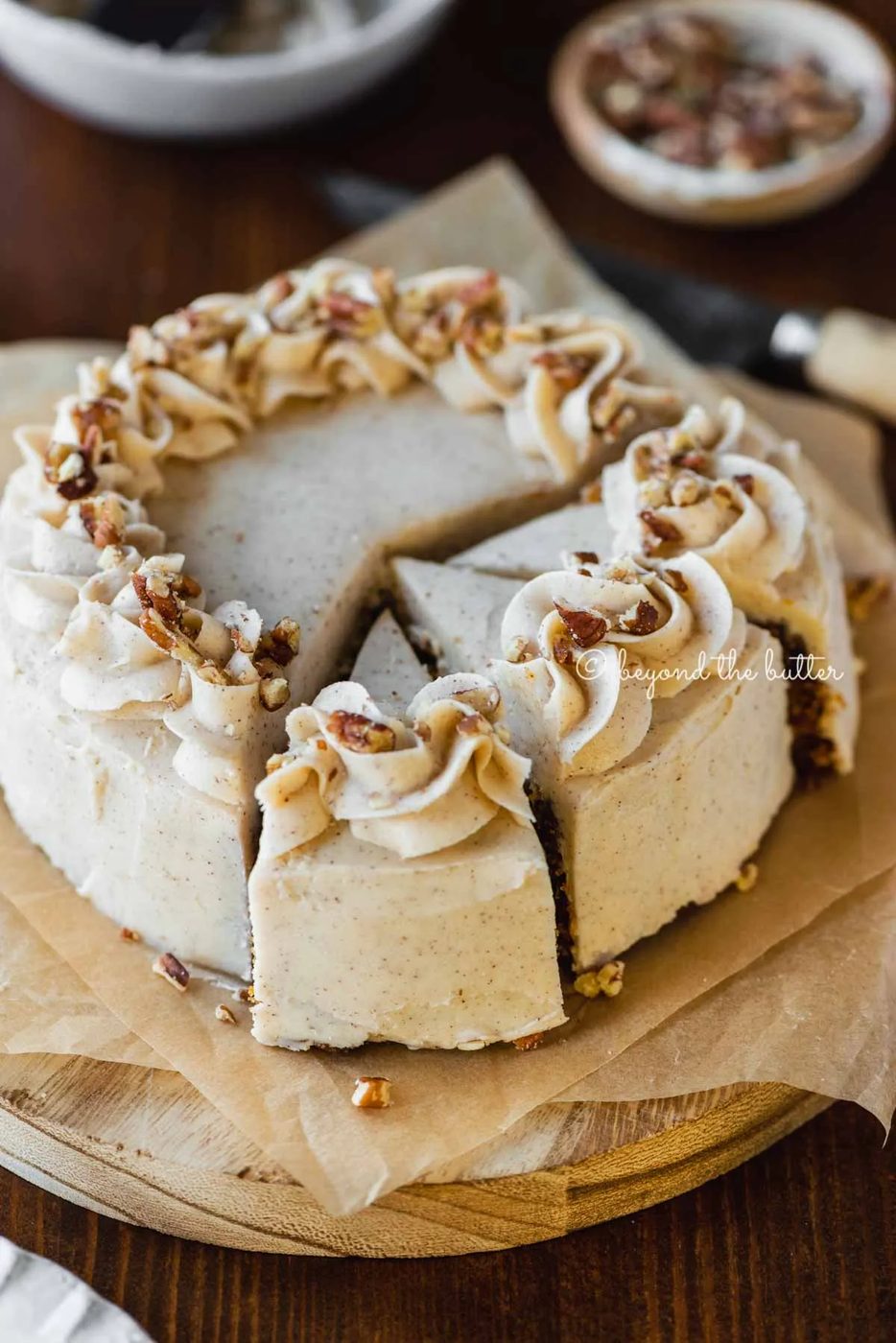 Angled overhead image of sliced 6 inch single layer carrot cake on parchment paper | All Images © Sovuh