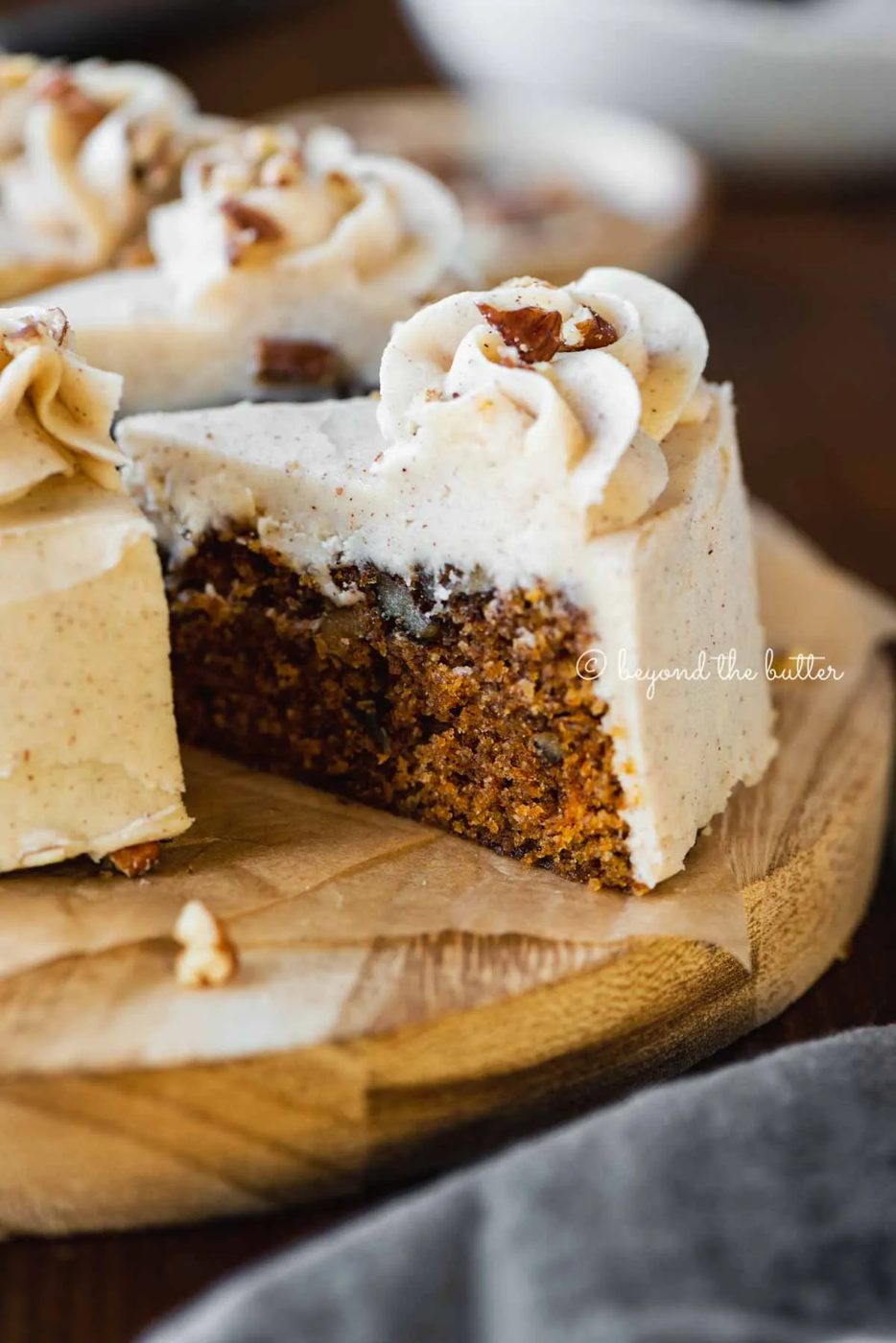 Angled closeup image of sliced 6 inch single layer carrot cake on parchment paper | All Images © Sovuh
