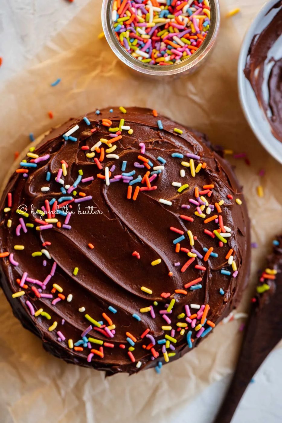 Overhead image of single layer chocolate cake with bowl of milk chocolate frosting | All Images © Sovuh
