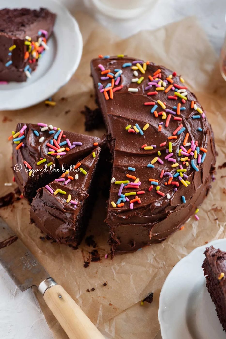 Angled image of sliced single layer chocolate cake on parchment paper | All Images © Sovuh