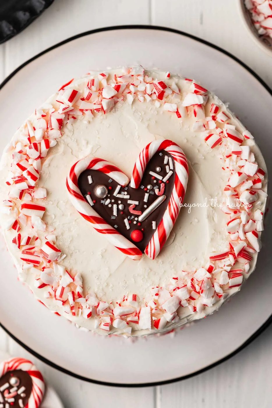 Single layer chocolate peppermint cake frosted with peppermint swiss merignue buttercream and garnished with crushed candy canes and candy cane heart | © Sovuh