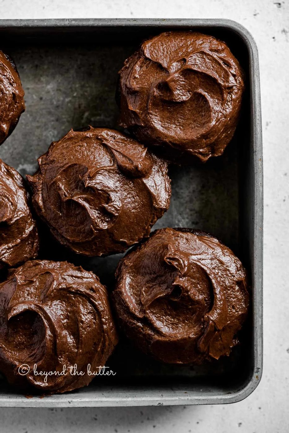 Overhead image of small batch chocolate cupcakes in vintage metal baking tin | All Images © Sovuh