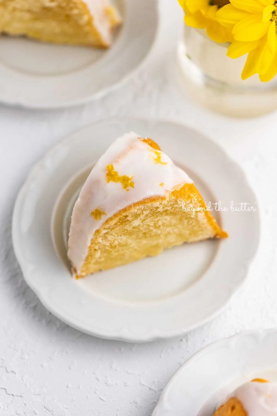 Small lemon cream cheese pound cake slice on a small dessert plate on white background | © Sovuh