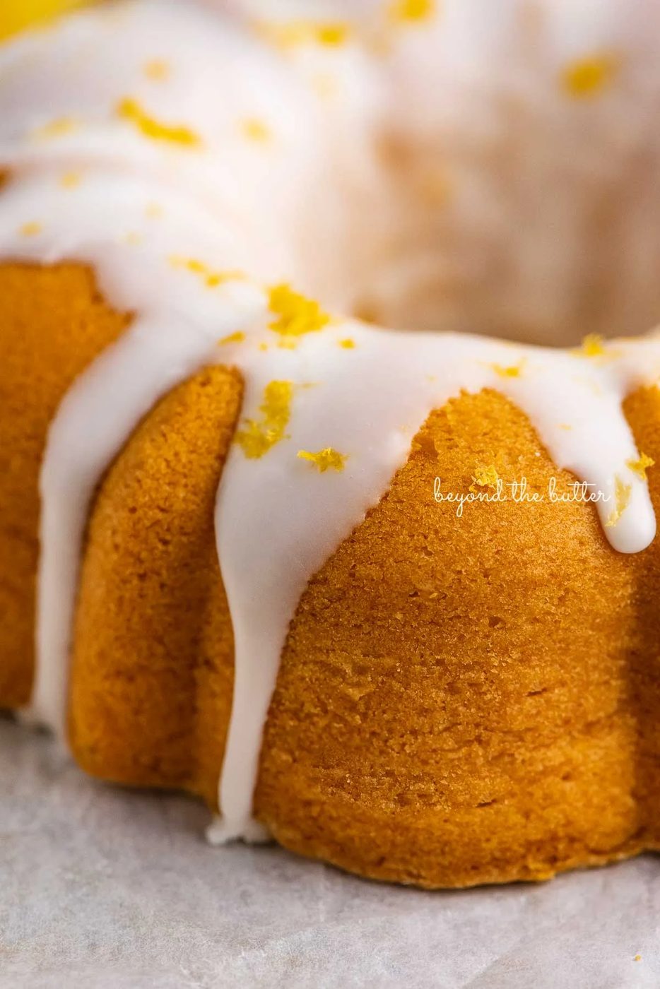 Close up image of lemon glazed small lemon cream cheese pound cake garnished with lemon zest | © Sovuh