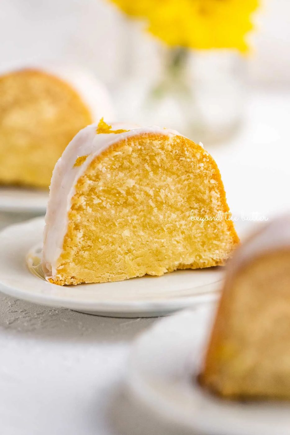 Small lemon cream cheese pound cake slice on a small dessert plate on white background | © Sovuh