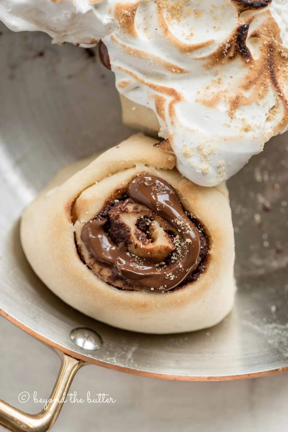 Overhead closeup image of s'mores rolls partially covered with marshmallow topping | All Images © Sovuh