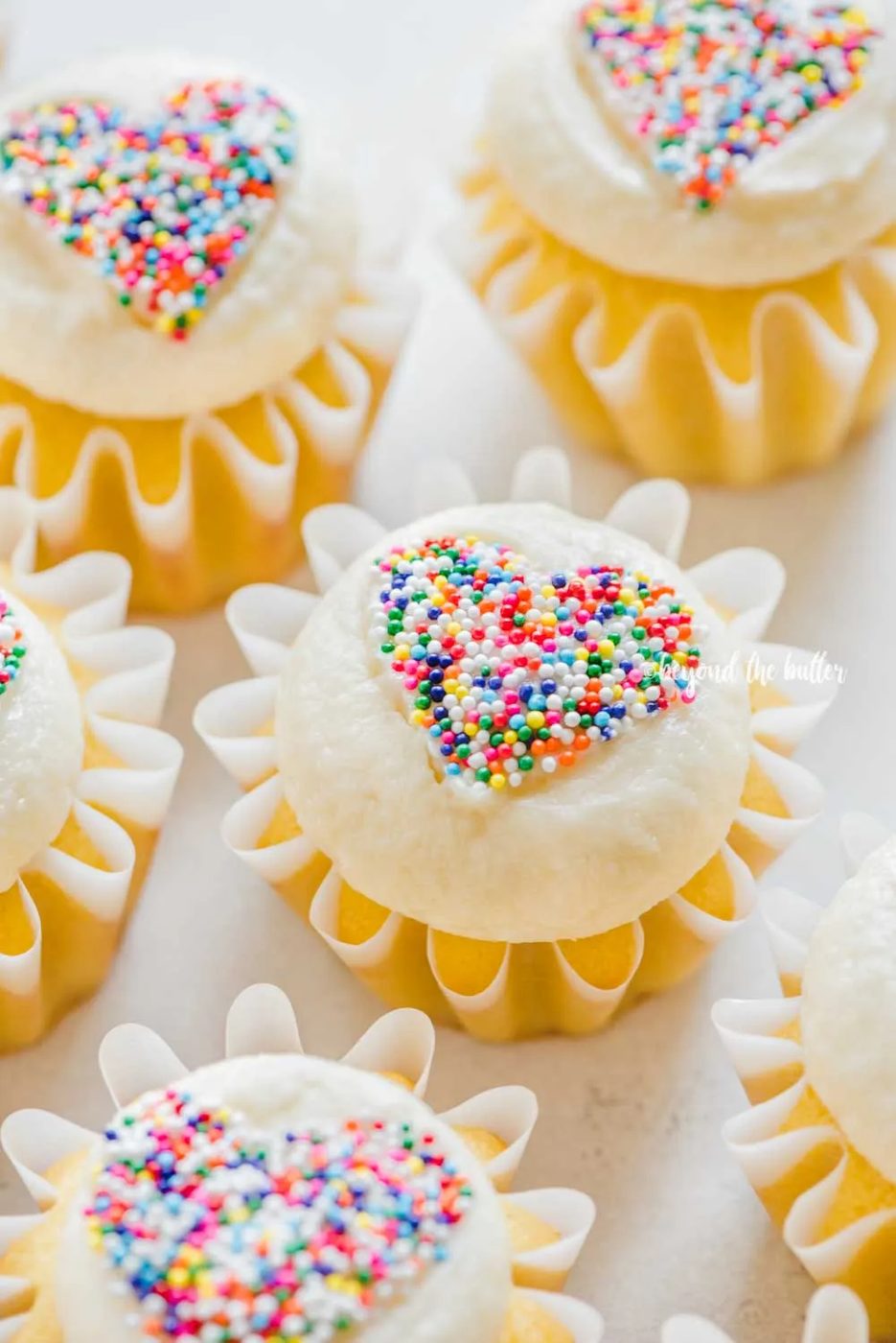 Angled image of sprinkled heart cupcakes on white/grya background | All Images © Sovuh