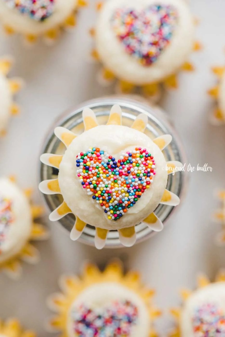 Overhead image of sprinkled heart cupcakes on white/grya background | All Images © Sovuh