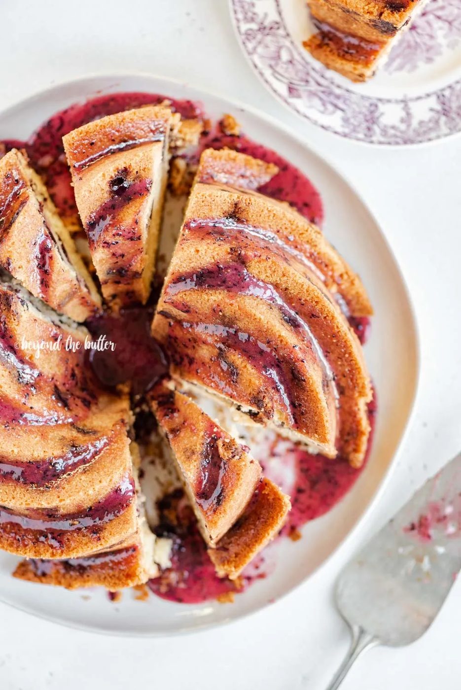 Overhead image of sliced blueberry bundt cake with blueberry glaze drizzled over the top | All Images © Sovuh, LLC