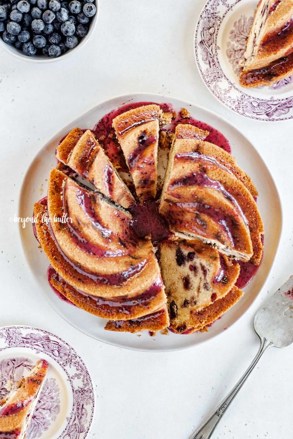 Overhead image of sliced blueberry bundt cake with blueberry glaze drizzled over the top | All Images © Sovuh, LLC