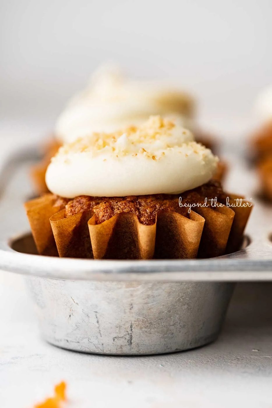 Closeup image of carrot cake cupcakes in a vintage cupcake tin | © Sovuh