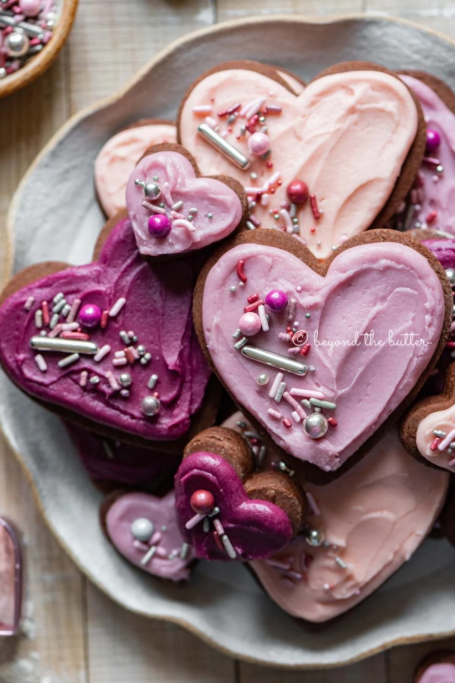 Plate full of chocolate cut out sugar cookies decorated with buttercream frosting and sprinkles | All Images © Sovuh