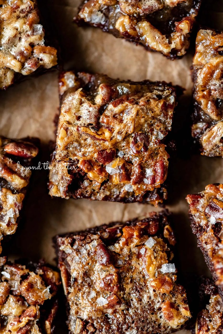 Salted pecan pie brownies placed on brown parchment paper | © Sovuh