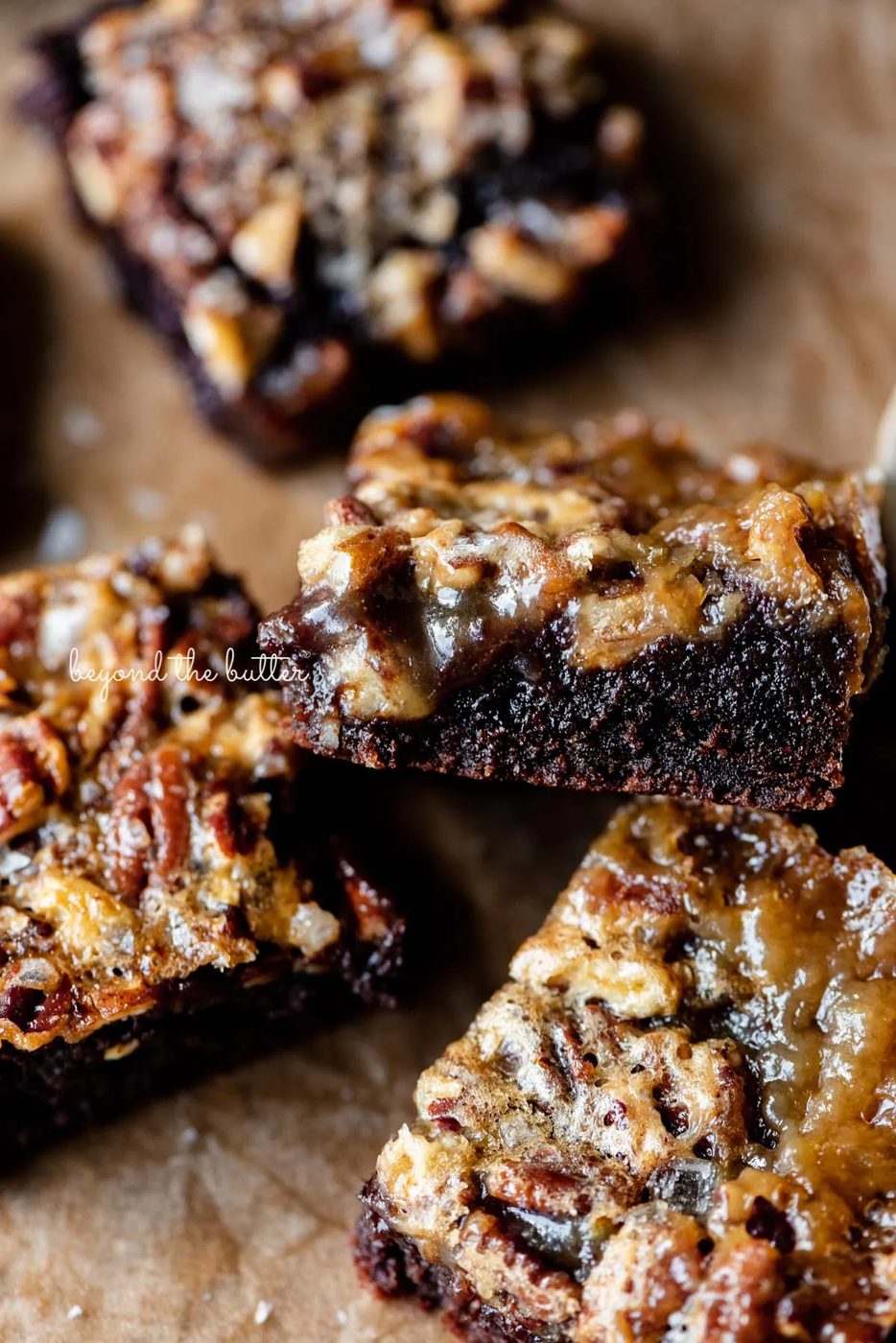 Salted pecan pie brownies placed on brown parchment paper | © Sovuh