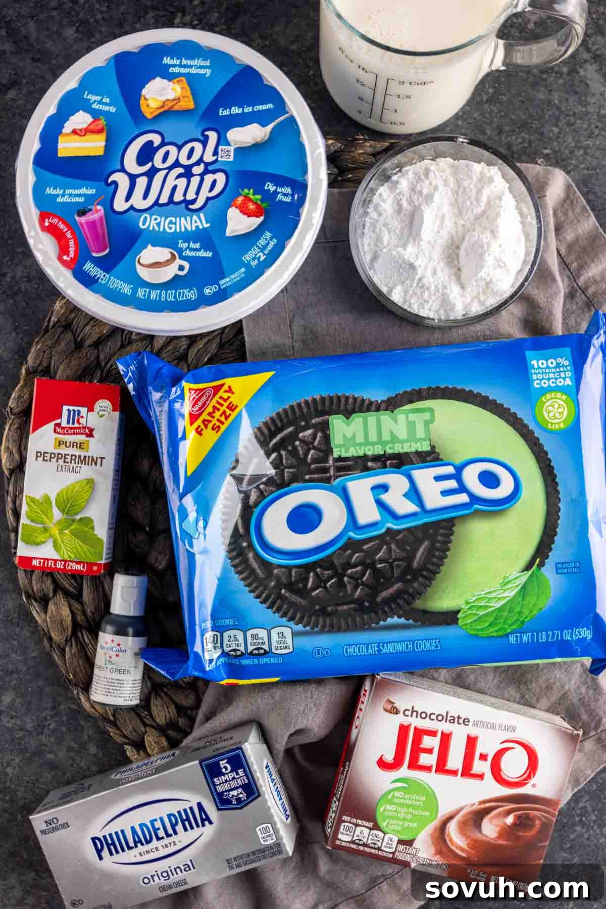 A vibrant flat lay of all the fresh ingredients needed for a mint oreo dessert, neatly arranged on a counter.