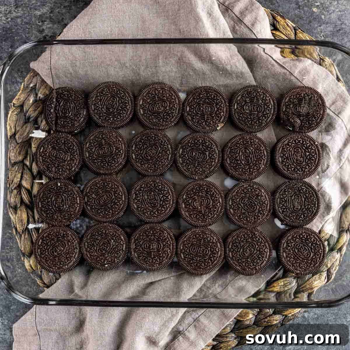 A bottom layer of milk-dunked Mint Oreo cookies arranged neatly in a glass 9x13 inch baking dish.