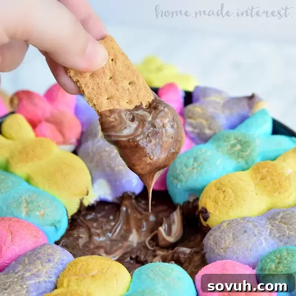 Easy Easter Peeps S'mores Dip in a cast iron skillet with toasted bunny marshmallows and melted chocolate, ready to be scooped with graham crackers.