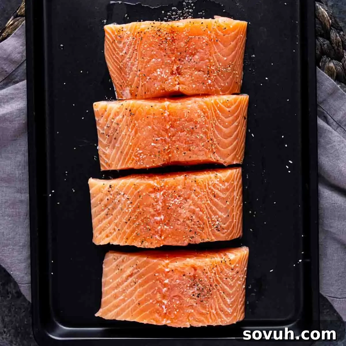 Citrus-Kissed Salmon 4 Four raw seasoned Orange Glazed Salmon on a baking sheet.