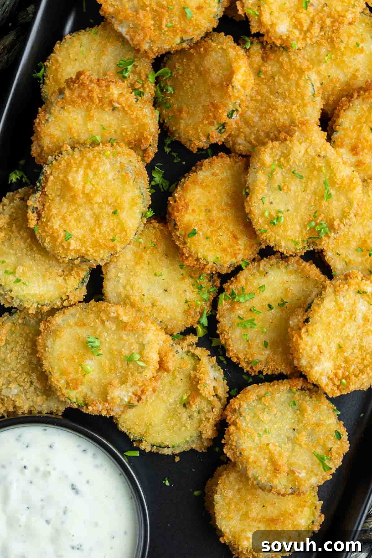 Crispy Zucchini Fritte arranged beautifully on a black plate.