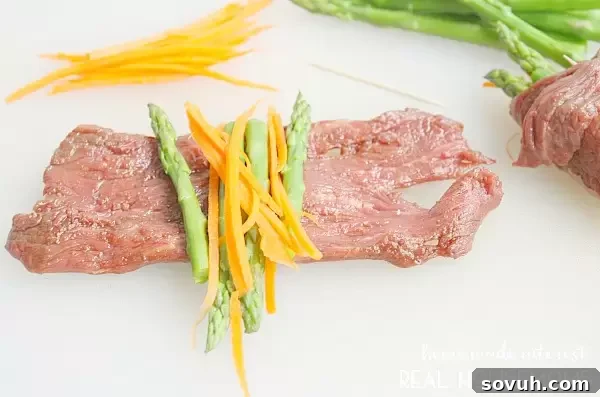 Preparing Balsamic Steak Roll Ups by laying out marinated flank steak slices and filling them with trimmed asparagus and thinly sliced carrots.