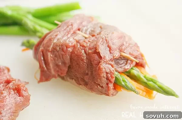 Securing Balsamic Steak Roll Ups with toothpicks after rolling flank steak around fresh vegetables.