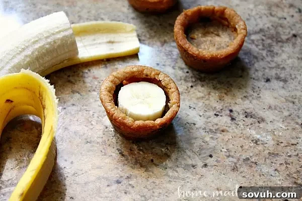 These easy banana split cookie cups are perfect for summer parties...or just a fun dessert for your family! Delicious cookie dough baked into cups and filled with chocolate, banana slices, whipped cream and of course a cherry on top. Who needs a plain old sundae when they could have a banana sundae cookie cup!