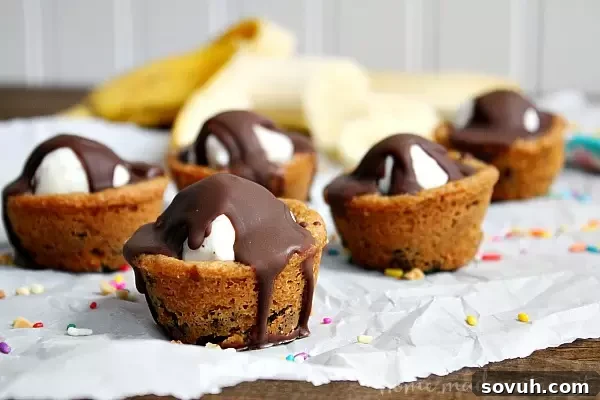 These easy banana split cookie cups are perfect for summer parties...or just a fun dessert for your family! Delicious cookie dough baked into cups and filled with chocolate, banana slices, whipped cream and of course a cherry on top. Who needs a plain old sundae when they could have a banana sundae cookie cup!