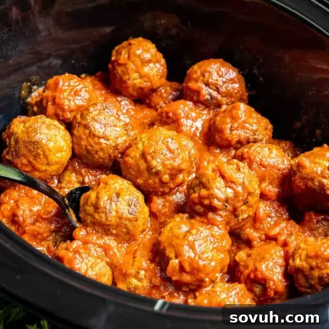 Frozen Meatballs in the Crock Pot with spoon in it