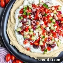 5 Layer Greek Dip on a plate with feta garnish