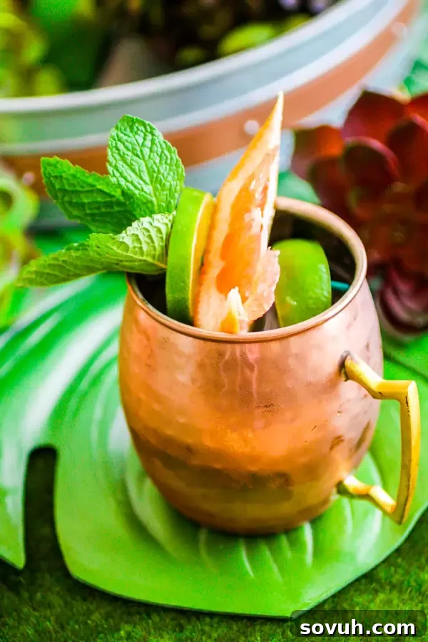 Citrus Moscow Mule in a copper mug garnished with lime and grapefruit