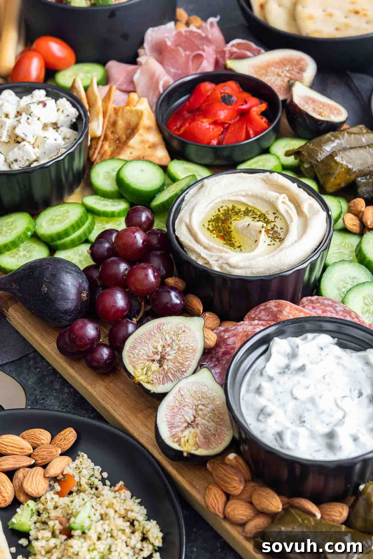 Hummus and various dips prominently featured in a Mediterranean Mezze Platter
