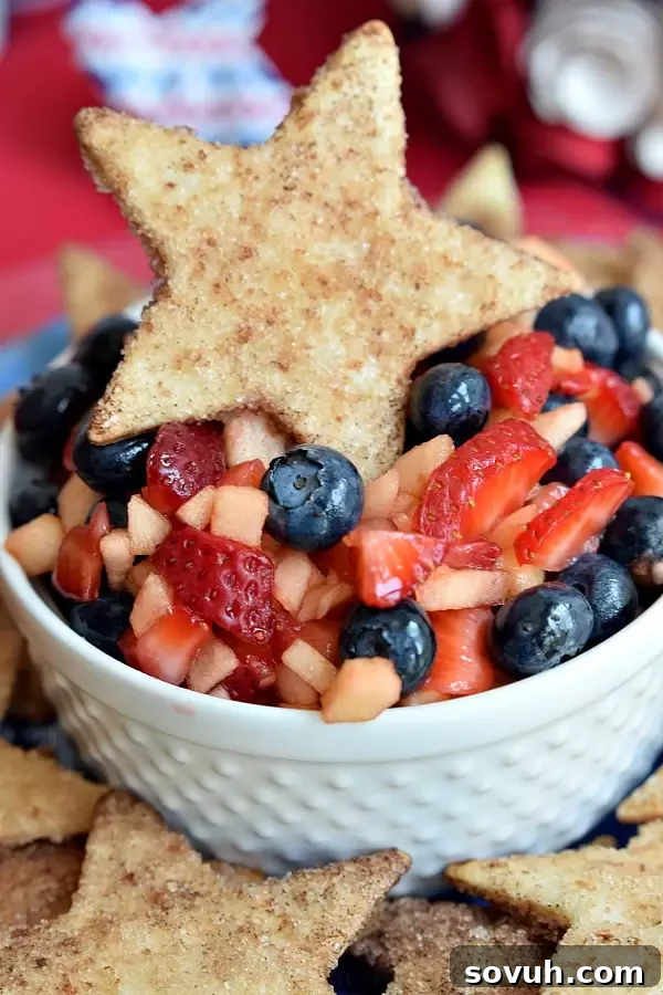 Vertical shot of Summer Fruit Salsa and star-shaped cinnamon chips, highlighting the patriotic colors, perfect for a 4th of July dessert table.