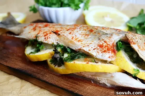 A perfectly cooked cedar plank grilled whole fish, seasoned with lemon and herbs, exuding a delicious smoky aroma. This easy grilled seafood recipe is ideal for any grill master.