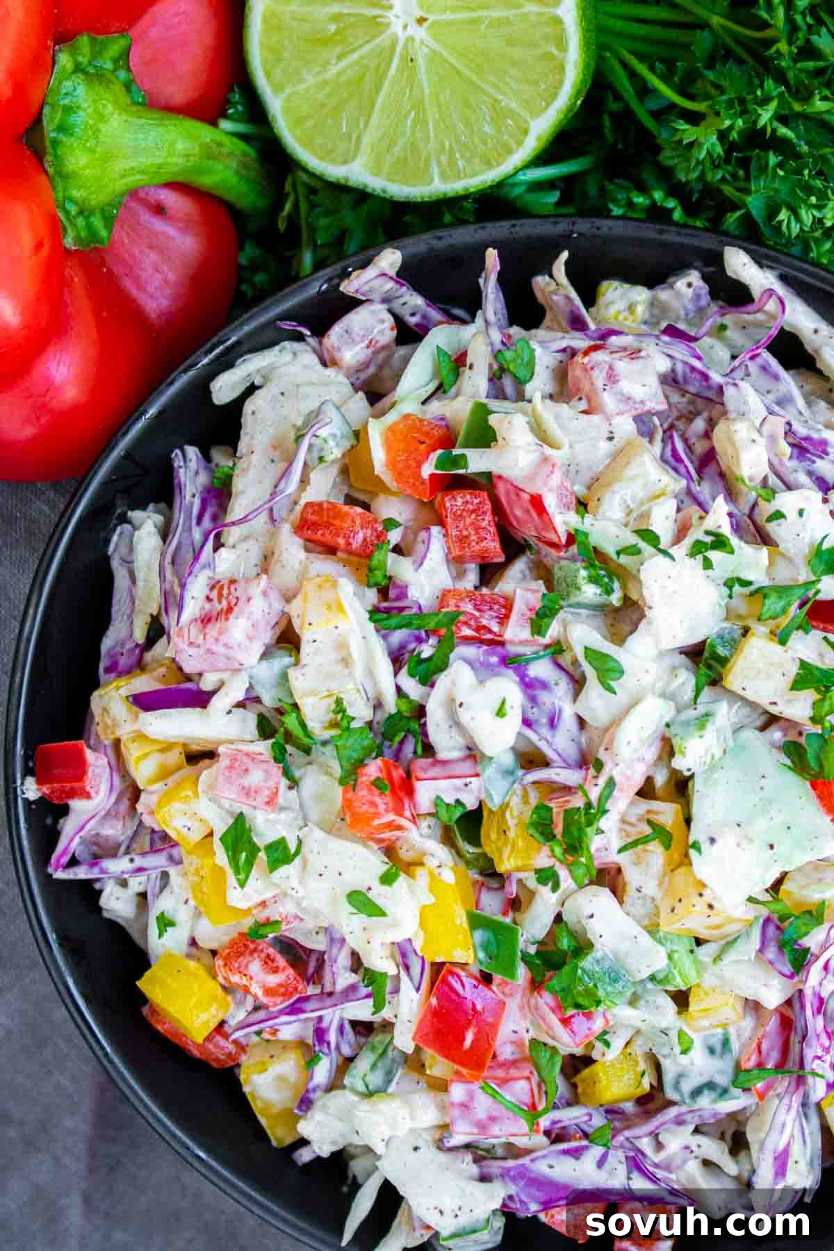 A bowl of vibrant Spicy Jalapeno Coleslaw, featuring crisp cabbage, colorful bell peppers, and finely diced jalapenos, tossed in a creamy dressing and ready to serve.