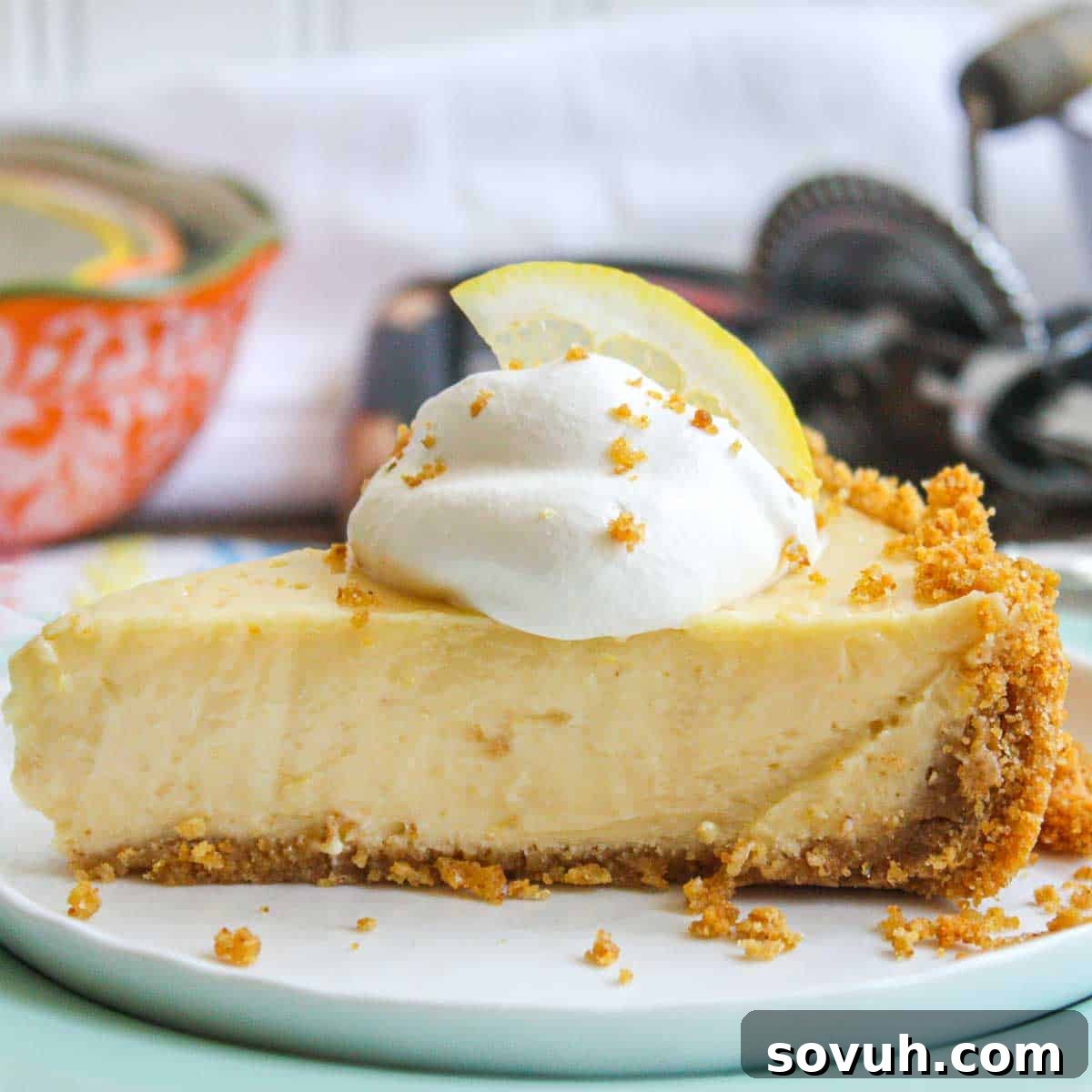 Zesty Lemon Icebox Pie 7 A close-up shot of a slice of Lemon Icebox Pie, revealing the golden brown graham cracker crust and the bright, creamy lemon filling.