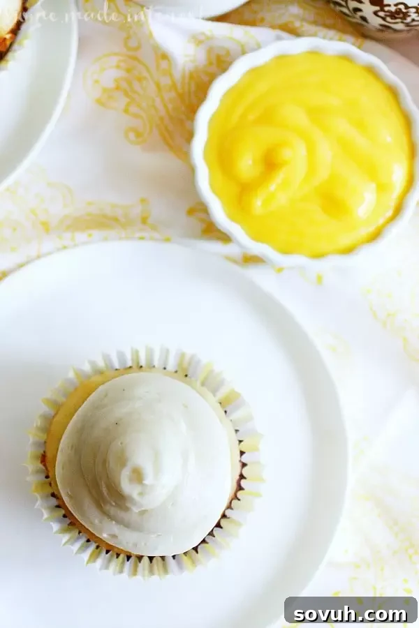 A beautifully frosted coconut mango cupcake, viewed from the top, highlighting the creamy texture and tropical appeal.