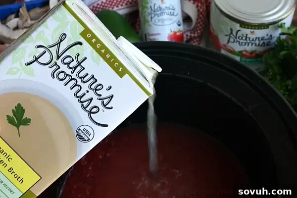 Making Slow Cooker Pizza Soup: Combine crushed tomatoes, tomato paste, and chicken broth in your crock pot for a flavorful base.
