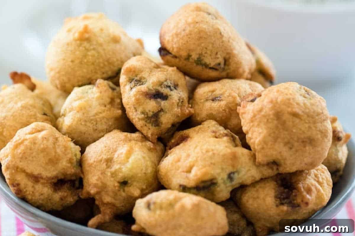 A generous bowl of golden, crispy Beer Batter Fried Brussels Sprouts, piled high and ready to be enjoyed with a creamy dipping sauce.
