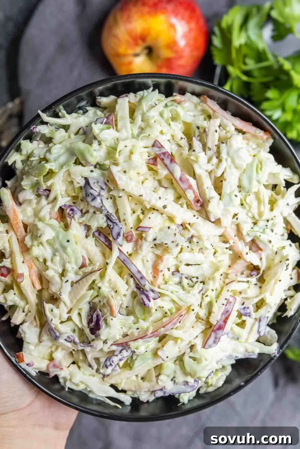 holding a black bowl of Apple coleslaw