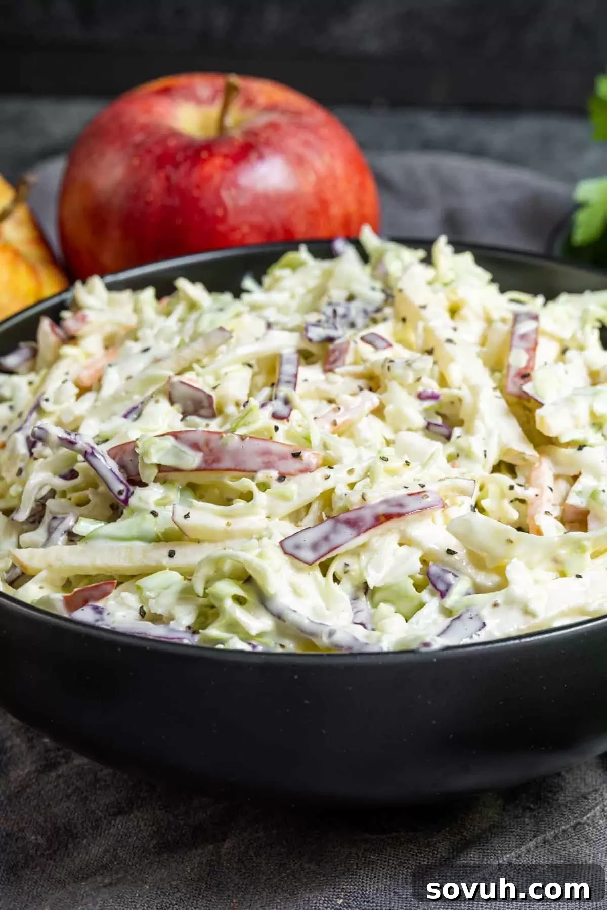bowl of Apple coleslaw with one apple in background