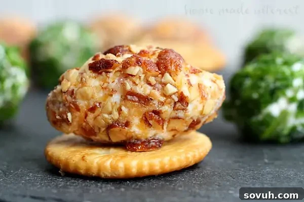 A vibrant platter of Game Day Bacon Cheese Balls, shaped like mini footballs and generously coated in chopped almonds, ready for sharing.