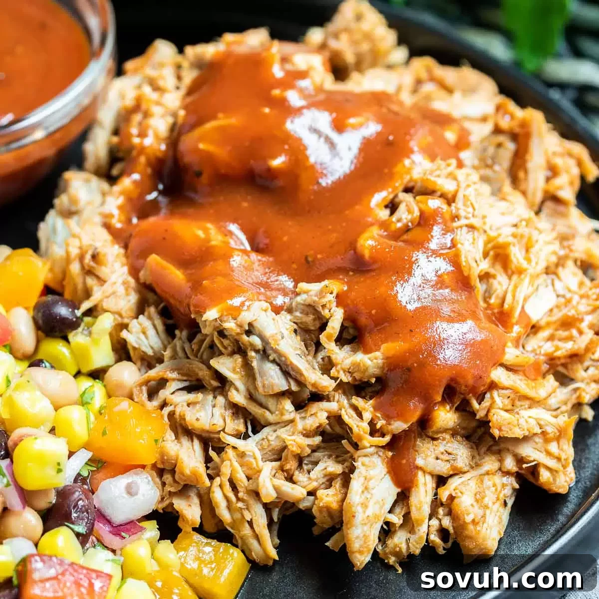 Homemade Pressure Cooker Pulled Pork covered in rich BBQ sauce, ready to serve on a rustic plate.