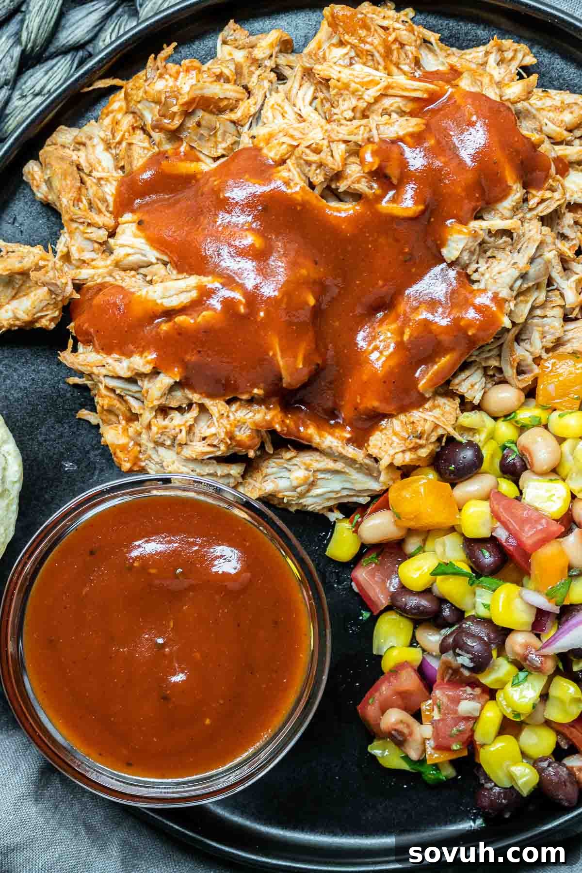 A plate featuring a generous serving of Instant Pot Pulled Pork with a swirl of BBQ sauce on a wooden board, inviting you to enjoy this quick BBQ meal.