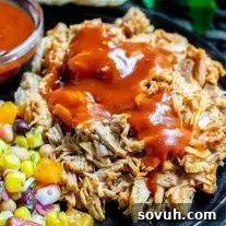 Pressure Cooker Pulled Pork with sauce on top, served fresh from the pot.