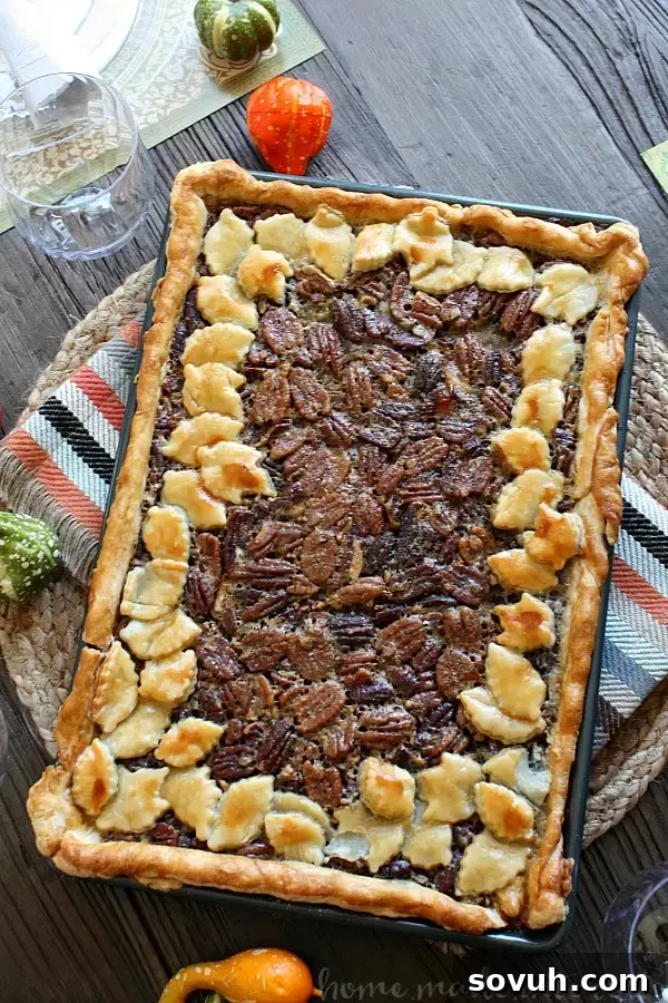 A vibrant, mouthwatering Pecan Slab Pie, adorned with decorative fall leaf crust, sliced and ready for serving on a rustic holiday table.
